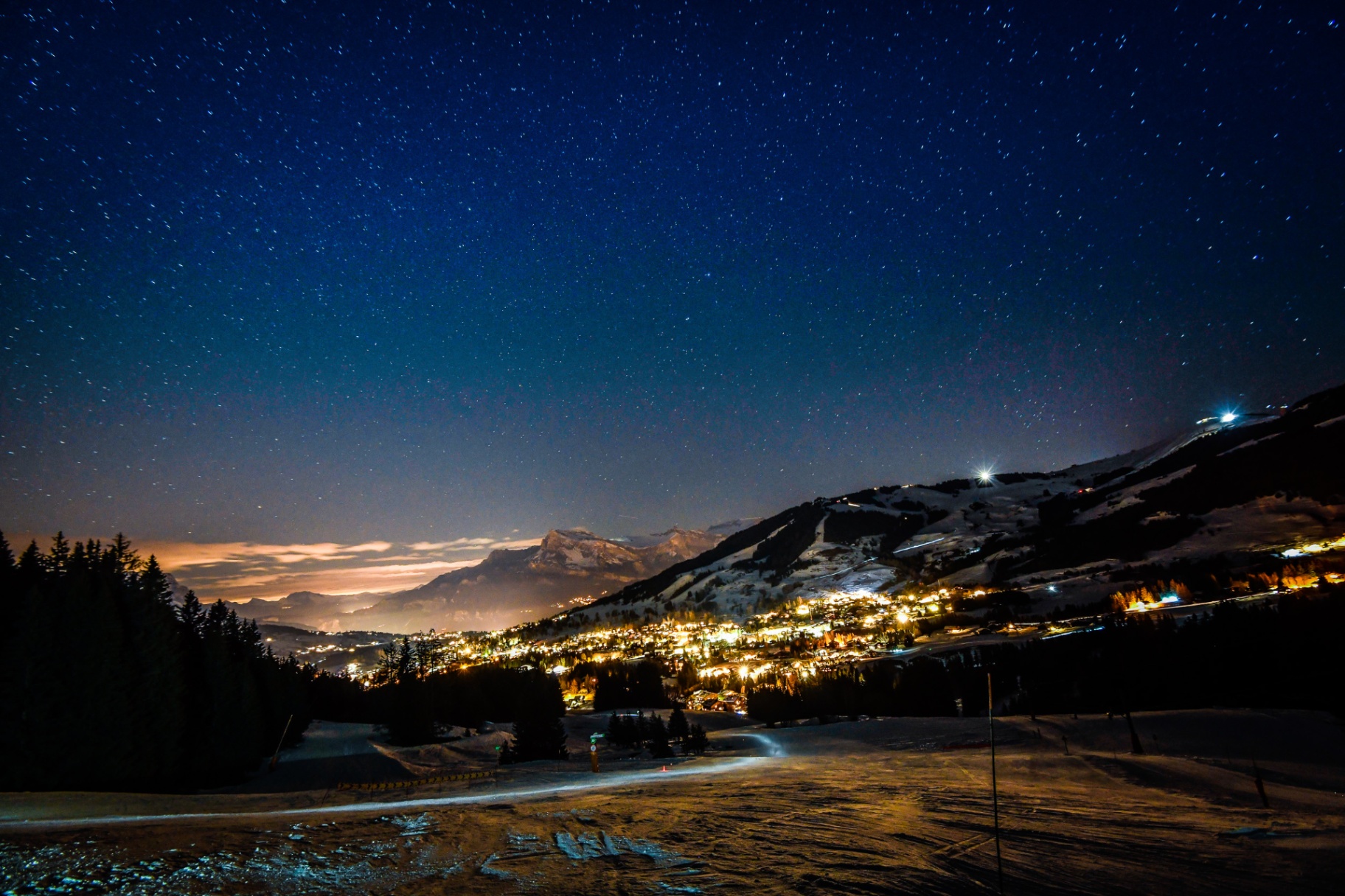 Vue nocturne de Megève avec les montagnes illuminées